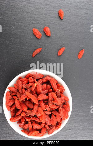 composition of dried goji berries in a small white bowl Stock Photo