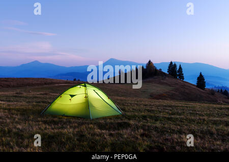 Green tent lighted from the inside Stock Photo