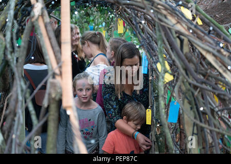 Glanusk Park, Brecon, Wales, 16th August 2018.  The first evening of the Green Man music festival in the Brecon Beacons Mountains in Wales. The site is opened the day before the festival proper. The huge Wicker Green Man sculpture is always one of the most popular areas with families and children. Credit: Rob Watkins/Alamy Live News Stock Photo