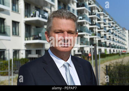 16 August 2018, Germany, Binz: Ulrich Busch, son of the worker-singer Ernst Busch, standing in front of Block 2 of the listed former KdF complex Prora. In 2006 Ulrich Busch bought two blocks of the former KdF NS property from the federal government for 455,000 Euros. Ulrich Busch was able to obtain building rights for both blocks with holiday and condominium apartments as well as hotel apartments from the municipality of Binz. Prora on Ruegen is officially termed a state-approved resort on 17 August 2018. In the medium term, the district of Binz aims to become a seaside resort. Photo: Stefan S