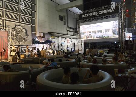 Tokyo, Japan. 17th Aug, 2018. People enjoy a movie sitting in small inflatable water pools on the rooftop of the revamped MAGNET by Shibuya109 building in Tokyo. Bathtub Cinema is held for the first time in Japan, which original concept is from London, people gathering to enjoy a movie and cool off on a outdoor bathing to escape from the high temperatures of this year that has sent thousands of people to the hospital for heatstroke. The event is held until August 19. Credit: Rodrigo Reyes Marin/ZUMA Wire/Alamy Live News Stock Photo