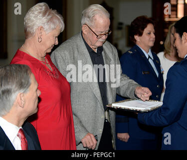 Edward Ferrell, Brig. Gen. Dawn M. Ferrell's father, prepares to pin on her new rank as her mother, Vivian Ferrell, and Texas Gov. Greg Abbott look on during her promotion ceremony Jan. 15, 2016, in the Texas Capitol's Senate Chambers. Abbott appointed Ferrell as the Deputy Adjutant General - Air for the Texas Military Department's Texas Air National Guard. Ferrell is the first female to hold the rank of general officer in the TXANG. (Air National Guard photo by 1st Lt. Alicia Lacy/Released) Stock Photo