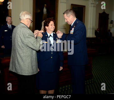 Edward Ferrell, Brig. Gen. Dawn M. Ferrell's father, and Brig. Gen. David McMinn, commander of the Texas Air National Guard, pin on her new rank during her promotion ceremony Jan. 15, 2016, in the Texas Capitol's Senate Chambers. Texas Gov. Greg Abbott appointed Ferrell as the Deputy Adjutant General - Air for the Texas Military Department's Texas Air National Guard. Ferrell is the first female to hold the rank of general officer in the TXANG. (Air National Guard photo by 1st Lt. Alicia Lacy/Released) Stock Photo