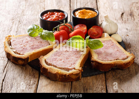 Spicy French pork terrine with brioche, vegetables and sauces close-up on the table. horizontal Stock Photo