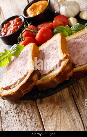 Pork terrine, pate with brioche with spices, garlic served with vegetables and sauces close-up on the table. Vertical Stock Photo