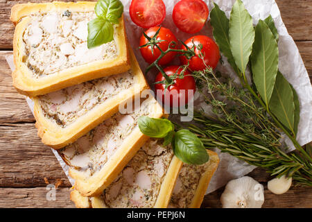 Chicken terrine in bread sliced into pieces close-up on the table. Horizontal top view from above Stock Photo
