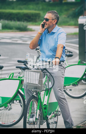 Man riding a bike in his way to work, concept of using city bike as environment friendly way of getting to work Stock Photo