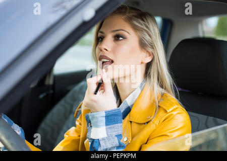 beautiful woman doing makeup in the car Stock Photo