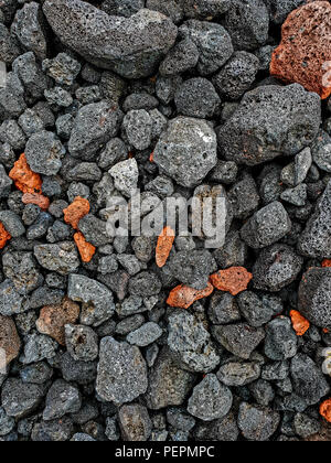 Red and black lava stones on the ground. background. Flat lay Stock Photo
