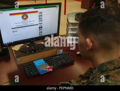 A Marine watches a YouTube video describing the details of Marine administrative message 001/16, which states that all permanent change of station travel expenses will now be paid using the government travel charge card. This change is expected to make travel more efficient and cost effective and to protect Marines from being charged interest on their personal accounts. For more information, watch the video at https://youtu.be/V7WMkMVX8GQ or contact your unit agency program coordinator. (U.S. Marine Corps photo by Cpl. Michelle Reif/Released) Stock Photo