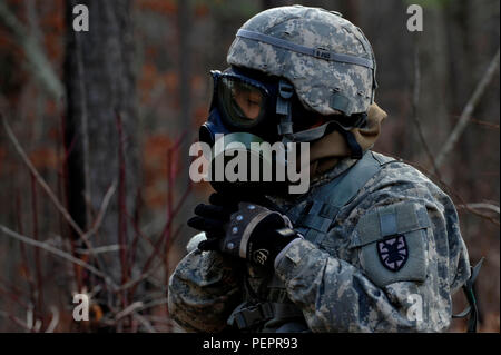 A U.S. Army Soldier, from the 73rd Transportation Floating Craft Company of the 19th Transportation Battalion, 7th Transportation Brigade (Expeditionary), puts on his gas mask in a simulated gas leak due to an explosion during a field training exercise at Fort A.P. Hill, Va., Jan. 12, 2016. FAPH’s training area was a combination of wooded and open areas and consisted of moderately level terrain with open fields bordered by dense to light vegetation areas. (U.S. Air Force photo by Senior Airman Breonna Veal) Stock Photo