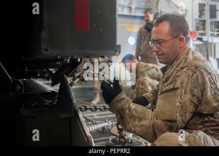 Tech. Sgt. Brock Hammer, Central Command Material Recovery Element team member, chains a 60K aircraft loader to a C-17 Globemaster III at Bagram Air Field, Afghanistan, before it is transported to Mazar-e-Sharif, Afghanistan, Jan. 18, 2016. The CMRE team is designed to account for and redeploy war reserve assets after they have fulfilled their intended purpose, so they are available for use elsewhere. (U.S. Air Force photo by Tech. Sgt. Robert Cloys) Stock Photo