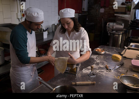 Bakers using machine for preparing pasta Stock Photo
