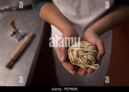 Baker holding tagliatelle in a hand Stock Photo