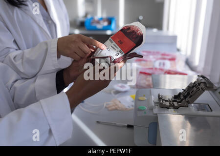Laboratory technicians discussing over blood bag Stock Photo