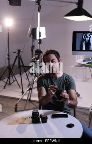 Male photographer cleaning camera lens Stock Photo