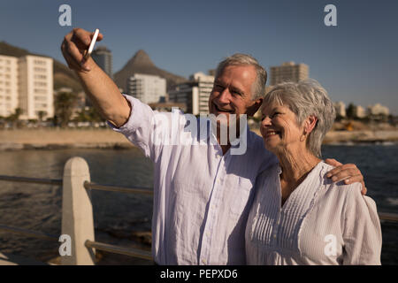 Senior couple taking selfies at promenade Stock Photo