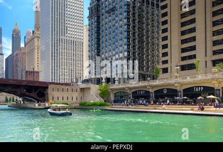 Chicago River with small boats and kayaks and The Riverwalk with surrounding downtown architecture in summer, Chicago, Illinois, USA Stock Photo