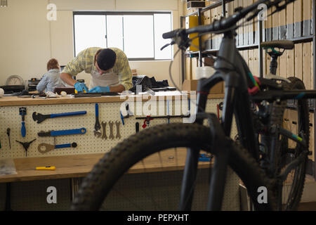 Man cleaning bicycle parts on counter Stock Photo