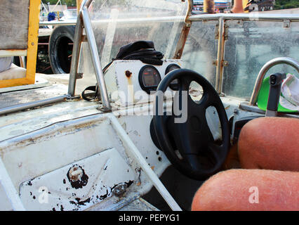 captain of the old boat with peeling white paint going while traveling by sea. Reportage shooting Stock Photo