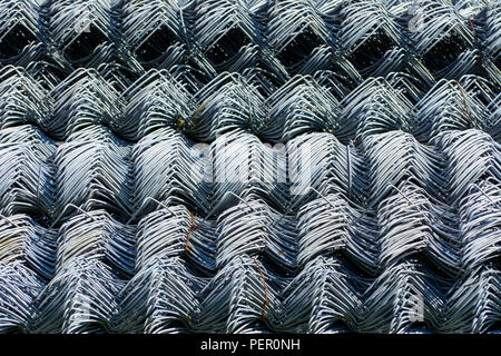 Rolls of galvanized steel wire mesh with a large cell and twisted pattern close-up. In the category of texture, screen saver, wallpaper. Stock Photo