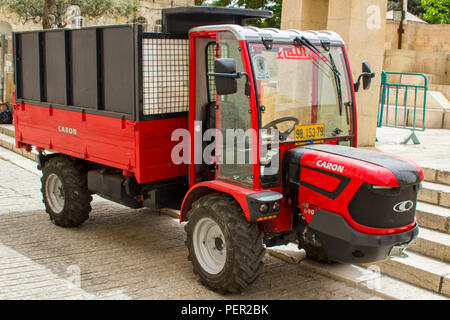 10 May 2018 A small tractor style vehicle and trailer back with high sidesused for ease of access to the narrow streets of the old city of Jerusalem I Stock Photo