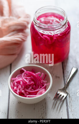 Homemade day pickled red onions in a handmade ceramic bowl and glass preserving jar. Stock Photo