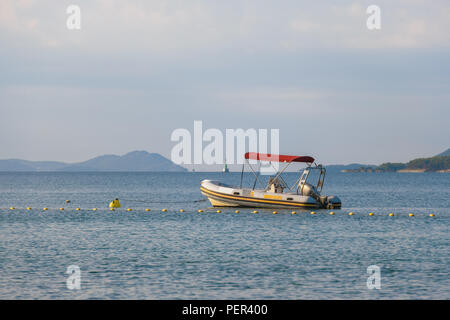 Small rubber motor boat, dinghy in morning light Stock Photo