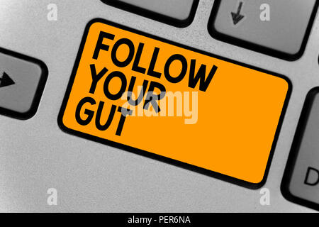 Word writing text Follow Your Gut. Business concept for Listen to intuition feelings emotions conscious perception Keyboard orange key Intention creat Stock Photo