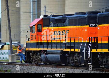 Mendota, Illinois, USA. A brakeman dropping down from the steps of a locomotive while working at the outer region of a freight yard. Stock Photo