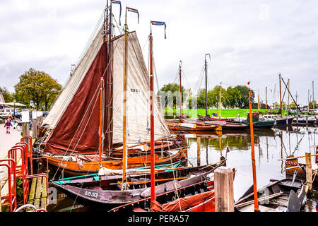 A flat bottom 'Botter' ship in full sail in the harbor of the historic and touristic Dutch fishing village of Elburg along the Ijsselmeer Stock Photo