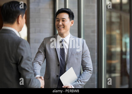 Cheerful businessmen shaking hands Stock Photo