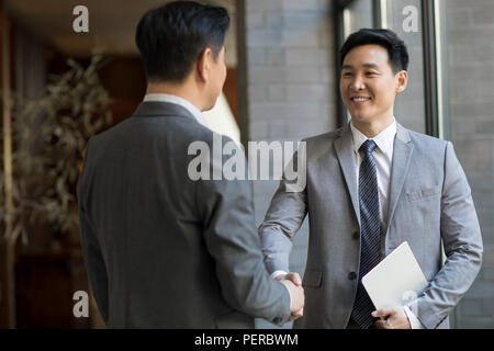 Cheerful businessmen shaking hands Stock Photo