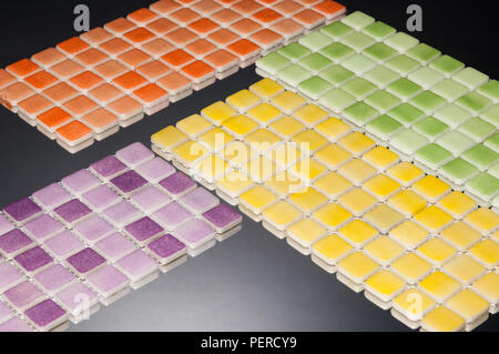 little multi-colored ceramic tile on a grey background with reflection, majolica. for the catalog Stock Photo