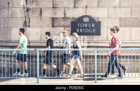 4 August 2018 - London, England. Group of tourists walking on old iconic, symbol of London - Tower Bridge. Stock Photo