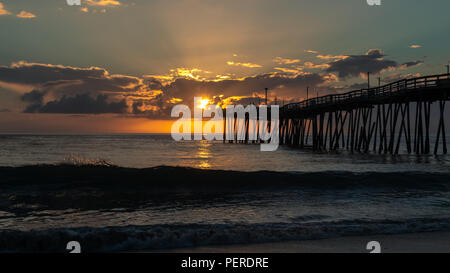 Light rays beam from behind morning clouds. Sunrise over the Atlantic Ocean. Stock Photo
