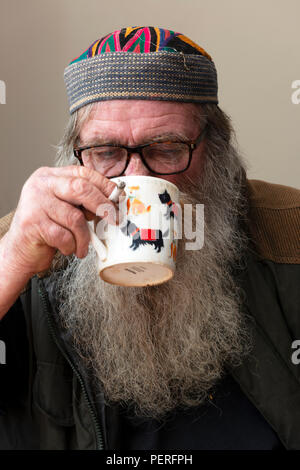 Elderly man smoking and drinking tea Stock Photo