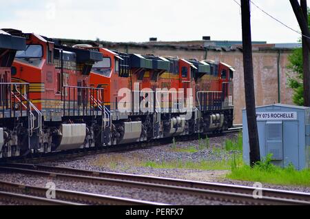 Rochelle, Illinois, USA. A wesbound Burlington Northern Santa Fe freight train led by five units runbles through a crossing. Stock Photo