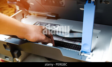 a man is repairing a printer. digital photocopier machine. printing equipment, 3d scanner Stock Photo