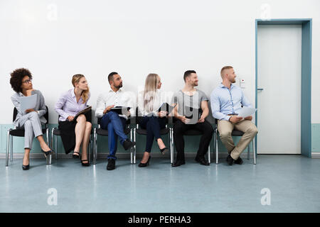 Candidates Sitting On Chair Waiting For An Interview Stock Photo