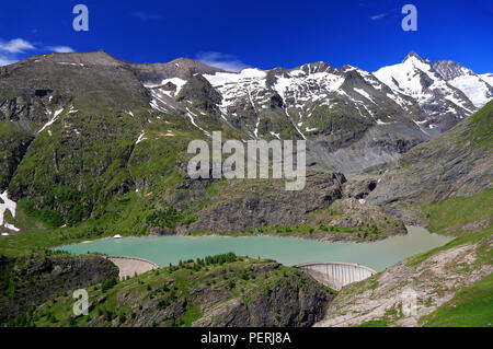 Grossglockner High Alpine Road and summit with green lake and dam on the foreground, Austria Stock Photo