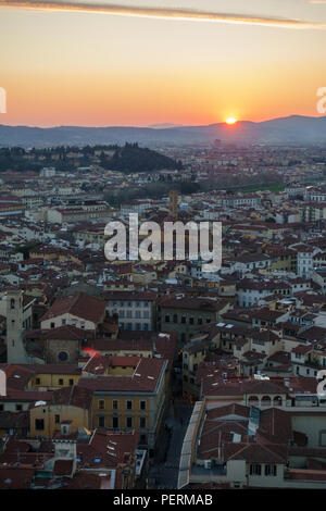 Florence, Italy - March 23, 2018: The sun sets over the hills of Tuscany and the cityscape of Florence, viewed from above. Stock Photo