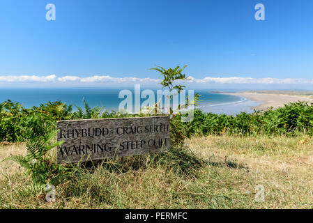 wooden sign saying 'warning Steep Cliff'. the sign is located on the Wales Coastal Path, above Rhossili beach, in the Gower Stock Photo