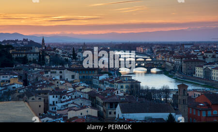 Florence, Italy - March 23, 2018: Evening light illuminates the cityscape of Florence along the Arno River, including the landmark Ponte Vecchio bridg Stock Photo