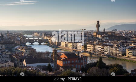 Florence, Italy - March 23, 2018: Evening light illuminates the cityscape of Florence along the Arno River, including the landmark Ponte Vecchio bridg Stock Photo