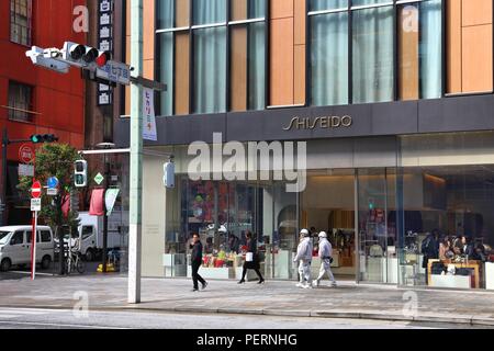 TOKYO, JAPAN - DECEMBER 1, 2016: People walk by Shiseido beauty store at Ginza district of Tokyo, Japan. Ginza is a legendary shopping area in Chuo Wa Stock Photo