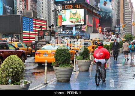 NEW YORK, USA - JUNE 10, 2013: People visit Times Square in New York. Times Square is one of most recognized landmarks in the world. More than 300,000 Stock Photo