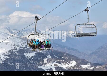 VALLOIRE, FRANCE - MARCH 24, 2015: Skiers go up the lift in Galibier-Thabor station in France. The station is located in Valmeinier and Valloire and h Stock Photo