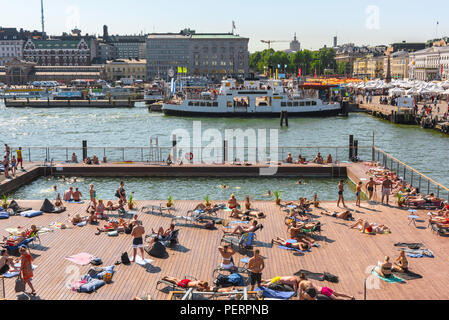 Helsinki harbor, view of the harbour in Helsinki with people relaxing in the waterfront Allas Sea Pool on a summer afternoon, Finland. Stock Photo