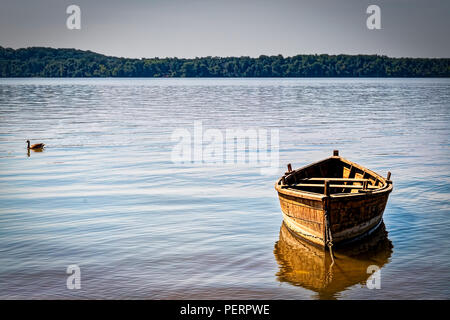 A small boat sits tide up to the shore of the Potomac River on the Virginia side. Stock Photo